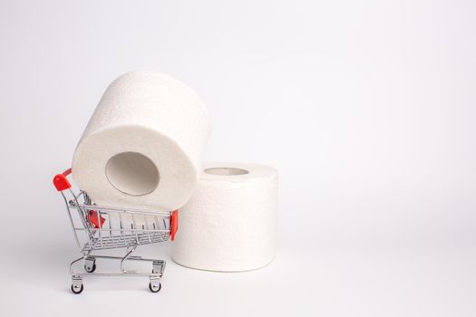 Roll of toilet paper in a toy trolley on a white background. Close-up. Panic purchase of toilet paper during quarantine. Stockpiling concept due to coronavirus outbreak