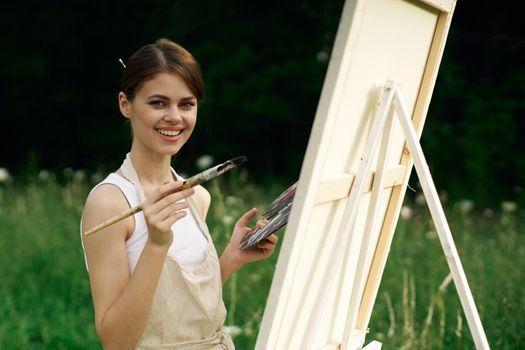 cheerful woman artist painting a picture outdoors creative art. High quality photo