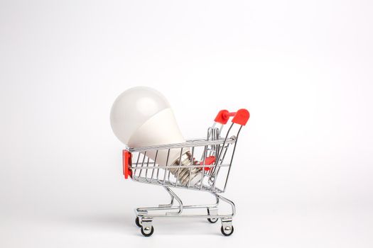 LED light bulbs on a cart, Isolated on white background. The concept of selling and buying business ideas, saving energy and cash