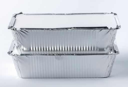 Foil food box with takeaway meal on white background close up