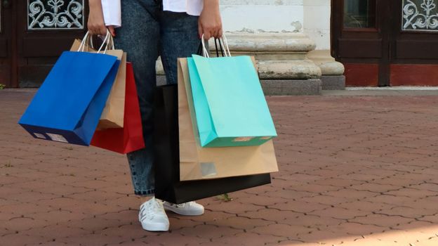 Shopaholic woman with paper shopping bags in her hands. Crop the photo. Consumerism, shopping, lifestyle concept. Copy space for your logo. shopping and sales season concept. Black friday thursday.