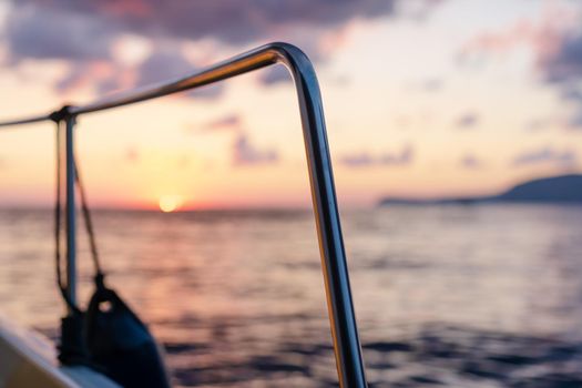 Deck of white yacht sailing in open sea at sunset, close up