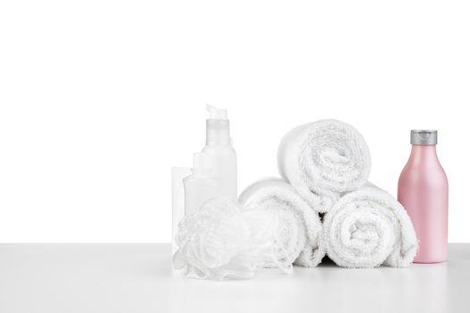 Composition of cosmetic bottles and towels isolated on white background