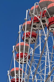 Ferris wheel on blue sky background. Closeup