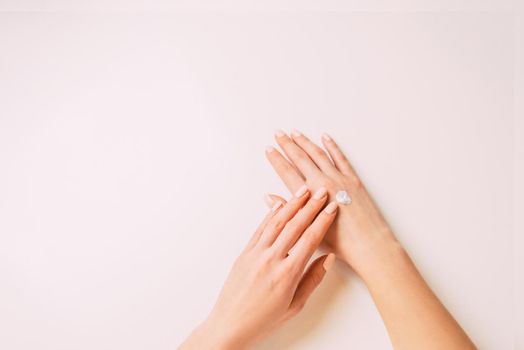 Young woman’s hands applying moisturizing cream, point of view. Copy-space in left part of image.