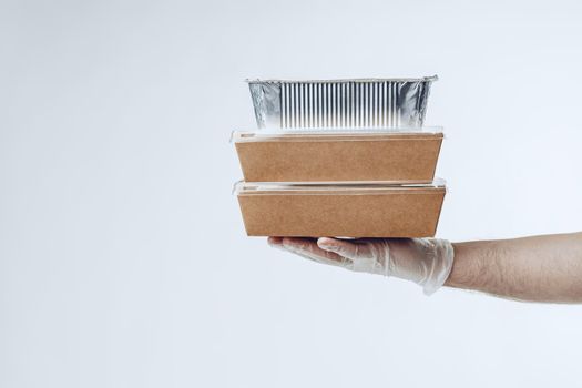 Courier hands in latex gloves giving packed food delivery close up