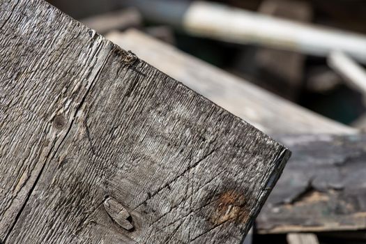 A stack of old wooden planks that lie on the ground