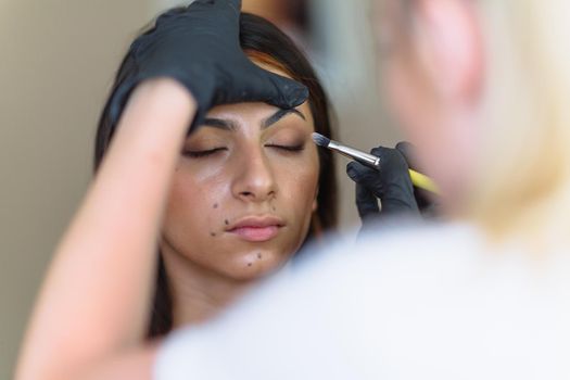 Makeup woman artist at work, professional in action with young model in beauty salon and creative classes