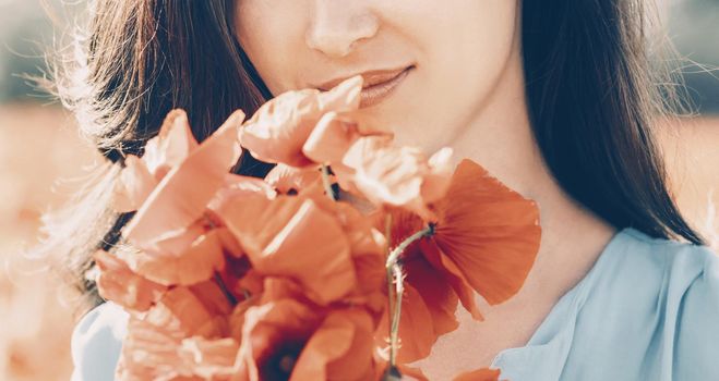 Smiling young woman with bouquet of poppies outdoor, close-up.