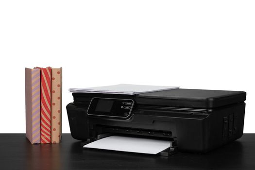 Working table with printer and stacked books on white abckground, close up