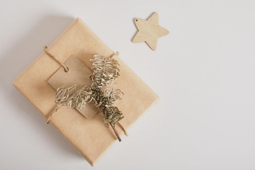 gift boxes with kraft paper on gray background, original gift decor with minimalistic eco-friendly christmas decor, spruce branch and pine cone
