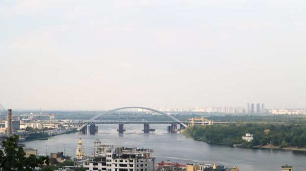 Top view of the old historical part of the city of Kiev. Vozdvizhenka area on Podol and the Dnieper river from the pedestrian bridge. Beautiful city landscape. Ukraine, Kiev - September 6, 2020