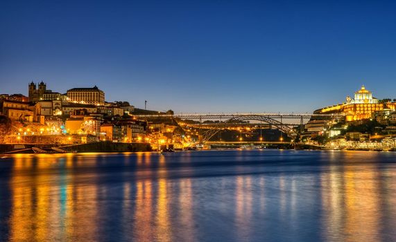 View of Porto along the river Douro at dawn with the famous iron bridge in the back