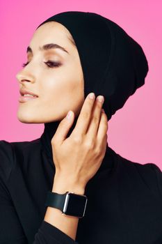 muslim woman with smart watch technology gadget pink background. High quality photo