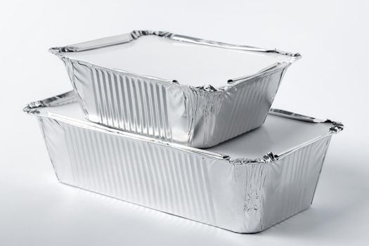 Foil food box with takeaway meal on white background close up