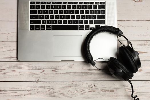 Notebook mockup and office rustic wooden desk with notebook, headphone and plant. Desk mock-up and top view minimalist design.