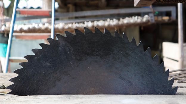 Old circular saw on wooden background with daylight. Carpentry work. Plunge saw blade for wood close up.