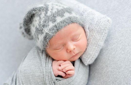 Cute newborn sleeping on tiny pillow lying on side