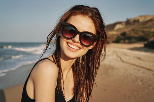 cheerful woman in sunglasses in a swimsuit on the beach sun island. High quality photo