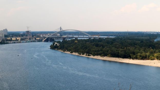 Top view of the old historical part of the city of Kiev. Vozdvizhenka area on Podol and the Dnieper river from the pedestrian bridge. Beautiful city landscape. Ukraine, Kiev - September 6, 2020