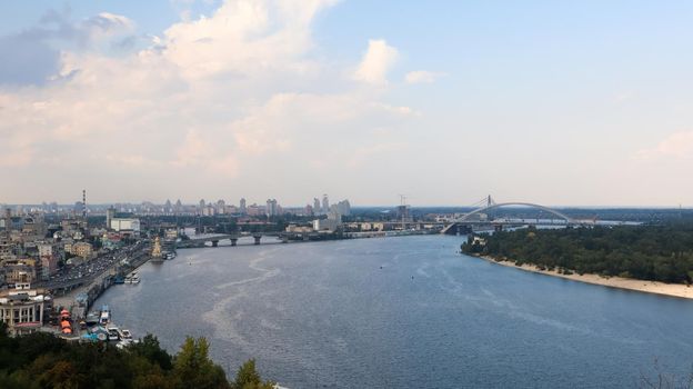 Top view of the old historical part of the city of Kiev. Vozdvizhenka area on Podol and the Dnieper river from the pedestrian bridge. Beautiful city landscape. Ukraine, Kiev - September 6, 2020