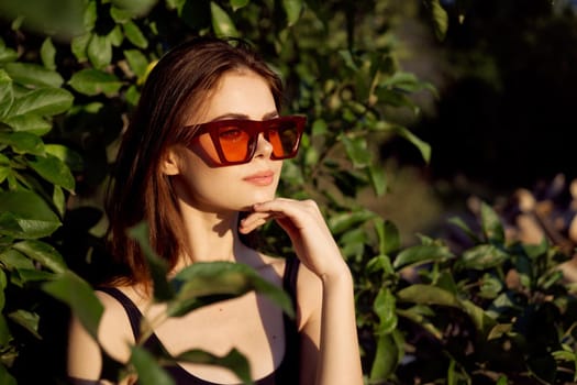 pretty woman wearing sunglasses green leaves glamor posing summer. High quality photo