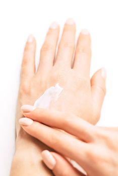 Young woman’s hands applying moisturizing cream for smooth skin, concept of skincare and beauty. Point of view image.