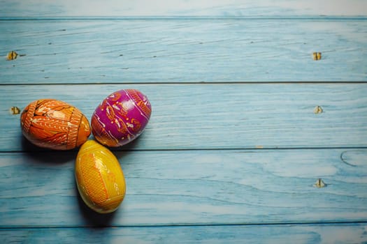 Easter colored painted eggs on blue wooden background flat lay with copy space