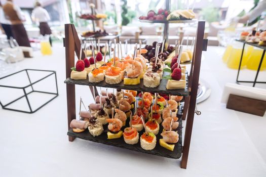 Different light snacks on tray at the table on wedding party