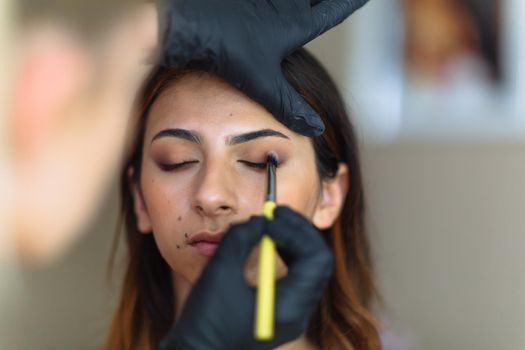 Makeup woman artist at work, professional in action with young model in beauty salon and creative classes