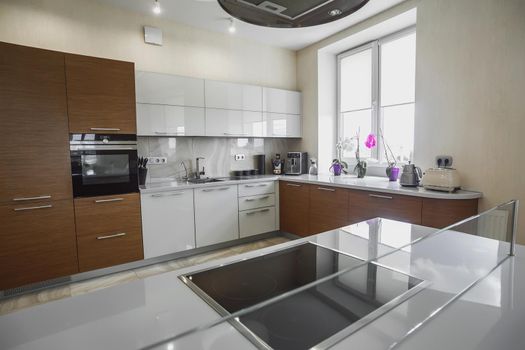 View of luxury expensive modern fitted kitchen with stainless steel appliances. Design of the kitchen room.