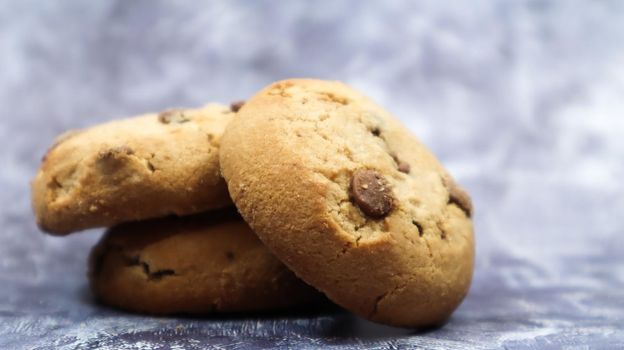 Soft, freshly baked chocolate chip cookies on a gray marble kitchen countertop. American traditional sweet pastry pastry, delicious homemade dessert. Culinary background