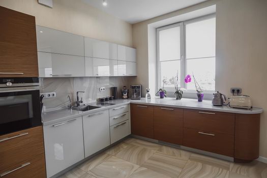 View of luxury expensive modern fitted kitchen with stainless steel appliances. Design of the kitchen room.