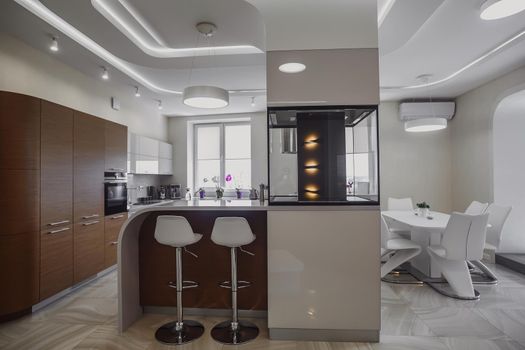 View of luxury expensive modern fitted kitchen with stainless steel appliances. Design of the kitchen room.