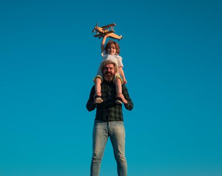 Father and son happy family. Boy sitting on fathers shoulders