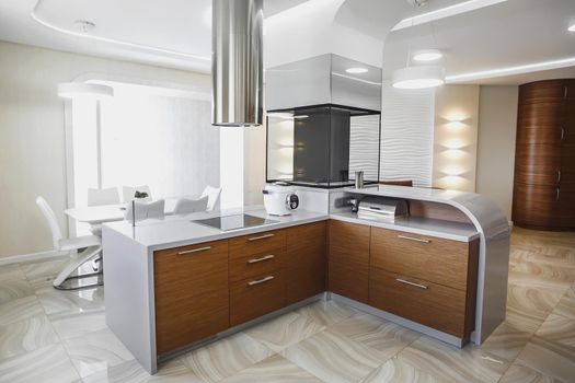 View of luxury expensive modern fitted kitchen with stainless steel appliances. Design of the kitchen room.