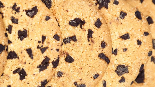 Soft, freshly baked chocolate chip cookies on a gray marble kitchen countertop. American traditional sweet pastry pastry, delicious homemade dessert. Culinary background. Close-up.