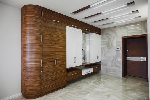 Wooden cabinet in modern hallway interior with luxury marble floor