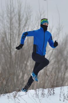 Male athlete running in winter, sport and leisure concept