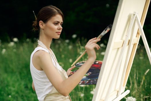 cheerful woman artist painting a picture outdoors creative art. High quality photo