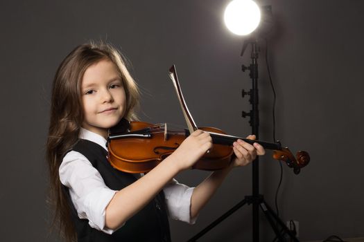 Beautiful girl with long hair playing violin