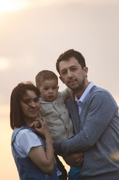 Portrait of a family of three at evening hill, telephoto shot