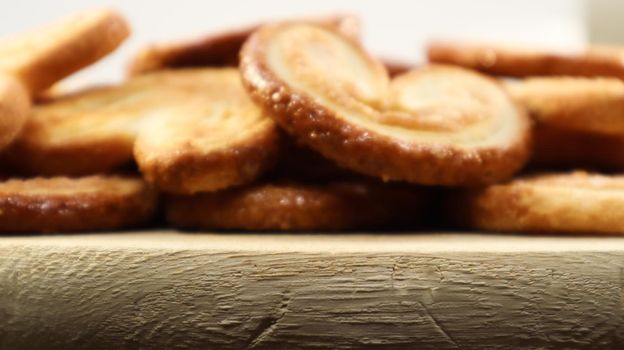 Fresh puff pastry palm cookies in the shape of a heart. Classic French pastries. Pig ear, elephant ear cookies, French hearts