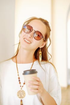 Portrait of cheerful woman with paper cup of coffee.