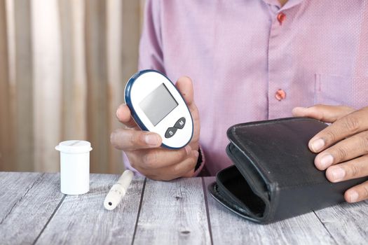 man's hand putting glucose meter in a small bag .