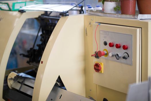 Control panel of the print press machine with buttons at printing factory, close up
