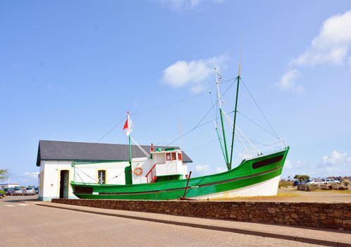 Old green fishing boat aground in France