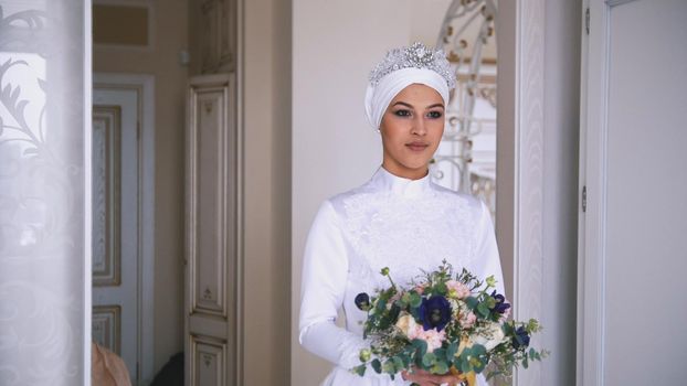 Beautiful muslim bride with make up in beautiful wedding dress with flowers