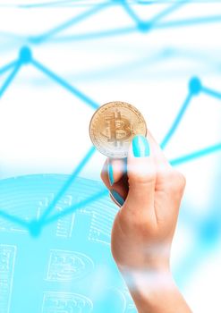 Female hand holding one gold bitcoins on background of blockchain scheme.