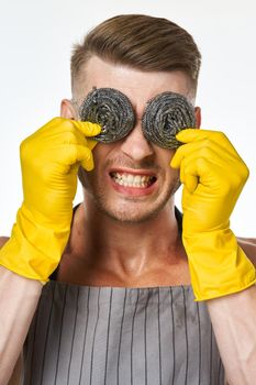 a man in a gray apron wearing rubber gloves cleaning washing. High quality photo